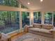 Sunroom with walls of windows, hardwood floors, and comfortable seating at 1408 Brigham Rd, Chapel Hill, NC 27517