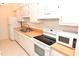 Kitchen with white cabinets, wood countertops, and appliances at 1511 Creekwood Ct # 102, Raleigh, NC 27603
