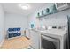 Well-equipped laundry room with modern washer and dryer, storage shelves, and bright lighting at 200 Callandale Ln, Durham, NC 27703