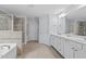 Main bathroom featuring double vanity, soaking tub, shower, and tiled floor at 200 Callandale Ln, Durham, NC 27703