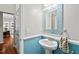 Stylish powder room with blue accent wall, decorative mirror, and pedestal sink at 200 Callandale Ln, Durham, NC 27703