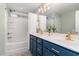 Bathroom with double vanity, blue cabinets, and a shower/tub combo at 206 Maple Walk St, Durham, NC 27703