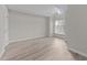 Light-filled bedroom with wood-look flooring and large window at 243 New Bern Pl # 301, Raleigh, NC 27601