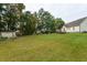 Expansive backyard with lush green grass, mature trees, playset, shed, and a wooden deck at 270 W Silverado Ct, Kenly, NC 27542