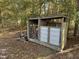 Exterior wood storage rack filled with logs, with room for storage on one side and a metal door on the other at 270 W Silverado Ct, Kenly, NC 27542