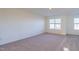 Well-lit bedroom with neutral carpet and large windows at 284 Johnson Ridge Way, Four Oaks, NC 27524