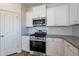 Modern kitchen features stainless steel appliances and white cabinetry at 308 Johnson Ridge Way, Four Oaks, NC 27524