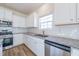 Kitchen boasts granite counters, white cabinets, and stainless steel appliances at 308 Johnson Ridge Way, Four Oaks, NC 27524