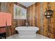 Relaxing bathroom with a freestanding tub and rustic wood feature wall at 40 Yellowstone Ct, Youngsville, NC 27596