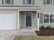 Dark gray front door with wreath and light-colored siding at 4236 Amber Stone Way, Durham, NC 27704