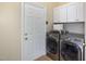 Laundry room with washer, dryer, cabinets, and tile flooring at 430 Federal Rd, Benson, NC 27504