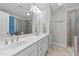 Bathroom with double vanity, framed mirror, modern fixtures, and tiled walk-in shower at 6 S Stonehaven Way, Clayton, NC 27527