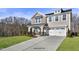 Two story house with gray siding, stone accents, and a two-car garage at 93 Macy Cir, Wendell, NC 27591