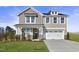 Two-story house with gray siding, stone accents, and a two-car garage at 93 Macy Cir, Wendell, NC 27591