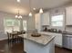 Eat-in kitchen with white cabinets, granite island, and breakfast nook at 110 White Ash Ln, Louisburg, NC 27549