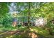 Wide backyard view of home surrounded by mature trees and lush green lawns at 11712 Black Horse Run, Raleigh, NC 27613
