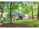 Spacious backyard view of brick home featuring lush green lawns and mature trees at 11712 Black Horse Run, Raleigh, NC 27613