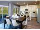 Open-concept dining area featuring hardwood floors, a large table for six, and sliding glass doors to a backyard at 1725 Pie Filling Dr, Haw River, NC 27258