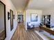 Hallway showing access to dining area, office and hall mirror and sconces, all accentuated by elegant wood floors at 1725 Pie Filling Dr, Haw River, NC 27258