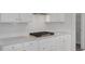 Bright white kitchen features a granite countertop, white cabinetry, and a stylish tiled backsplash at 18 Fairwinds Drive Dr, Lillington, NC 27546