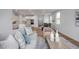 Bright, open-concept living room with hardwood floors flows into the modern white kitchen at 18 Fairwinds Drive Dr, Lillington, NC 27546