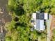 Aerial view showcases a modern house with a pool and solar panels, nestled among trees and river at 196 Paces Mill Trl, Pittsboro, NC 27312