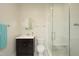 Well-lit bathroom with a walk-in shower, a dark vanity, and a round mirror at 196 Paces Mill Trl, Pittsboro, NC 27312
