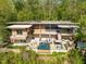 An exterior view of a modern home featuring an outdoor pool and lounge area nestled in nature at 196 Paces Mill Trl, Pittsboro, NC 27312