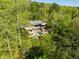 Scenic aerial view featuring a modern home with an in-ground pool among lush green trees at 196 Paces Mill Trl, Pittsboro, NC 27312