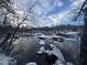 Winter view of a partially frozen river with rocks covered in snow, and bare trees at 196 Paces Mill Trl, Pittsboro, NC 27312