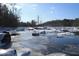 Picturesque icy river view with scattered rocks, snow and leafless trees on a bright winter day at 196 Paces Mill Trl, Pittsboro, NC 27312