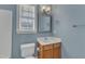 Bathroom features a vanity, toilet and window with blue walls at 215 W Chestnut Ave, Wake Forest, NC 27587