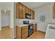 View of kitchen with wood cabinets, black appliances, and a back door at 215 W Chestnut Ave, Wake Forest, NC 27587