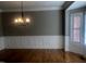 Formal dining room with hardwood floors, chandelier, and wainscoting at 223 Shalimar Dr, Durham, NC 27713