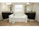 A spacious bathroom featuring a tub, double vanities and windows at 248 Begen St, Morrisville, NC 27560