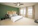 A large bedroom with tray ceilings, a modern headboard and carpeted floors at 248 Begen St, Morrisville, NC 27560