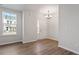 Bright living room with hardwood floors, a modern chandelier, and natural light from a large window at 277 Chesapeake Commons St # 94, Garner, NC 27529