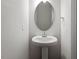 Classic pedestal sink with oval mirror and chrome fixtures in a simple powder room at 277 Chesapeake Commons St # 94, Garner, NC 27529