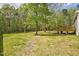 A lush backyard boasts mature trees and a wooden deck, perfect for enjoying the outdoors at 2857 Greenbrook Dr, Wendell, NC 27591