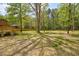 The spacious backyard features mature trees and a wooden deck, creating a serene oasis for outdoor enjoyment at 2857 Greenbrook Dr, Wendell, NC 27591