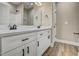 A bathroom features a double vanity with white cabinets, stone countertop, and modern fixtures, offering convenience at 2857 Greenbrook Dr, Wendell, NC 27591