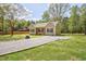 Home exterior showcasing gravel driveway, manicured lawn, blue shutters, and covered porch at 2857 Greenbrook Dr, Wendell, NC 27591