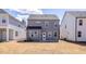 The backyard of a modern two-story home with gray siding, visible windows, and a level, unfinished yard at 34 Fairwinds Dr, Lillington, NC 27546