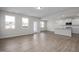 Spacious open-concept living area with hardwood floors and bright kitchen in the background at 34 Fairwinds Dr, Lillington, NC 27546