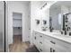 This bright primary bathroom has a double vanity and access to walk-in closet and tiled shower at 404 Andrews Rd, Durham, NC 27705