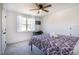 Cozy bedroom featuring a ceiling fan, gray carpet, and a sunny window with white trim at 404 Andrews Rd, Durham, NC 27705