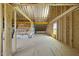 Unfinished attic with exposed beams and plywood flooring at 5377 River Buck Rd, Spring Hope, NC 27882