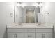 Bright bathroom with double vanity, modern lighting, and large mirror reflecting the glass-enclosed shower at 5377 River Buck Rd, Spring Hope, NC 27882