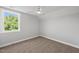 This bedroom features neutral walls and carpeting, a large window, and a modern ceiling fan at 5377 River Buck Rd, Spring Hope, NC 27882