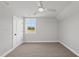 This bedroom features neutral walls and carpeting, a large window, and a modern ceiling fan at 5377 River Buck Rd, Spring Hope, NC 27882